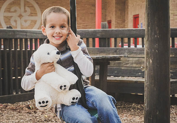 child with stuffed bear 